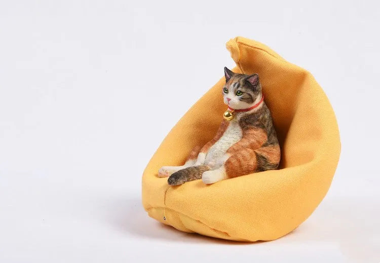 Small resin cat figurine on a sofa, a 1:6 scale car dashboard ornament.