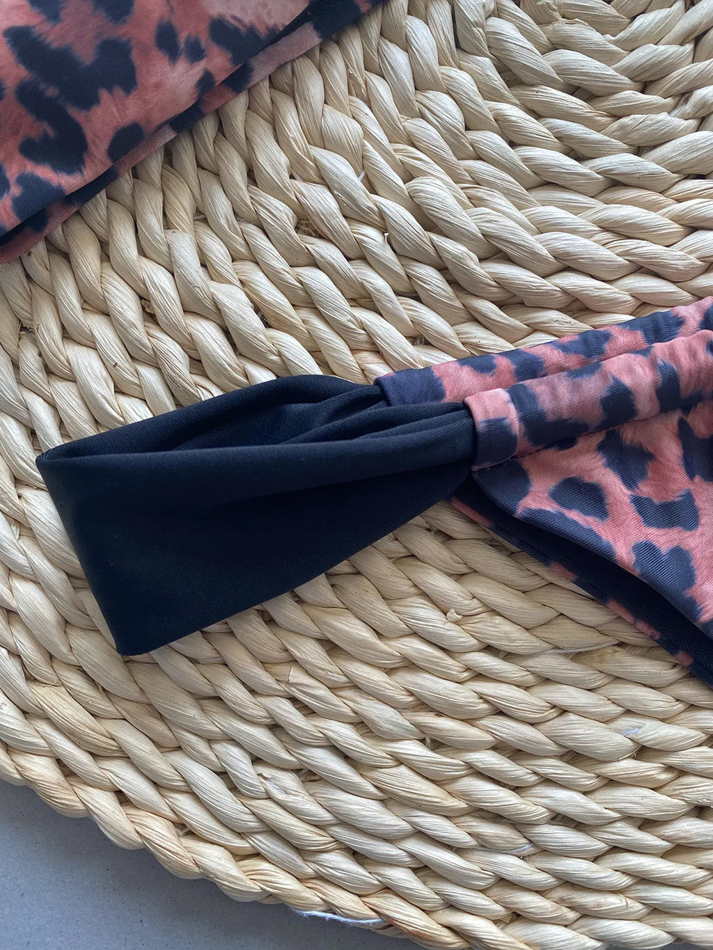 Women's leopard print bandeau bikini set with split top and T-pants bottoms.