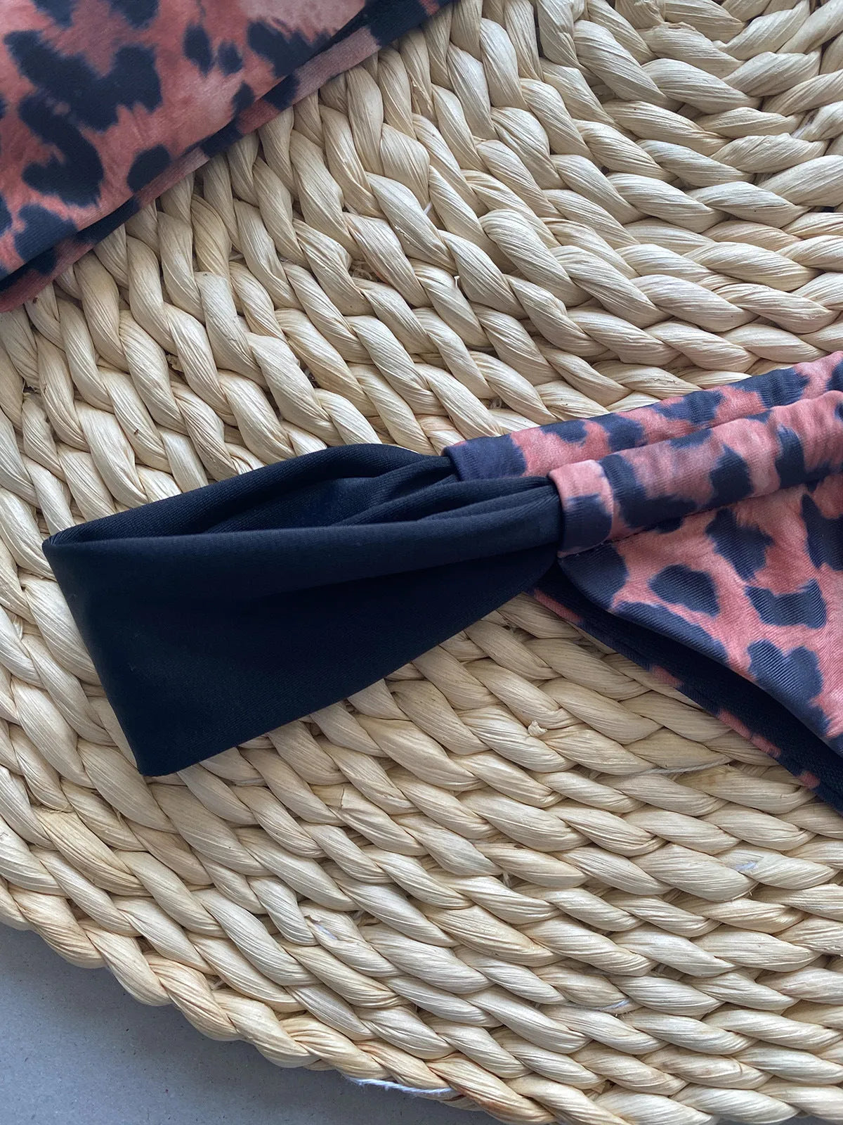 Women's leopard print bandeau bikini set with split top and T-pants bottoms.