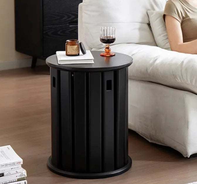 Two stackable round iron stools with splayed legs in a modern kitchen, showing smoked black and cream white colour options.