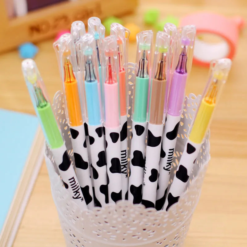 Box of 12 cow print coloured gel pens with 0.38mm fine tips on a desk.