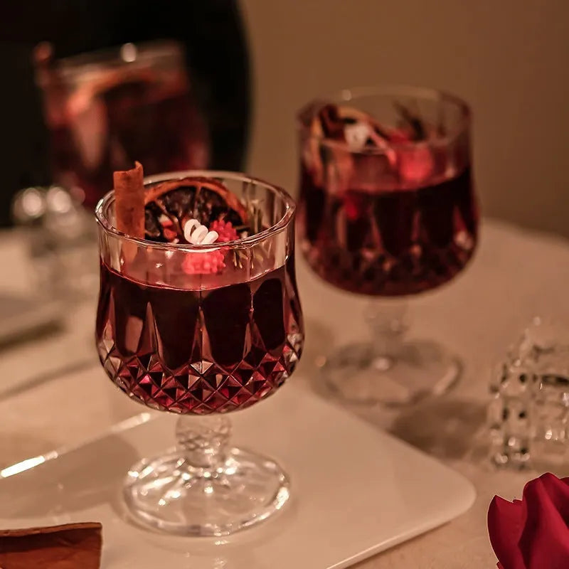 Glass wine goblet shaped container holding a French mulled wine scented aromatherapy candle.