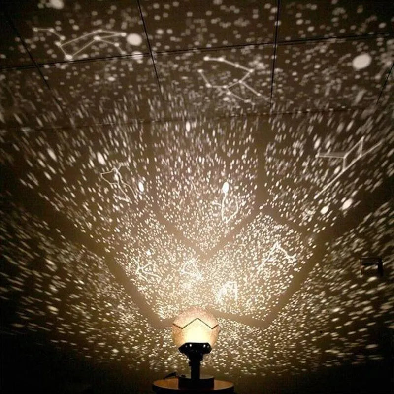 LED starry sky projector night lamp on a table projecting constellations onto a dark bedroom ceiling.
