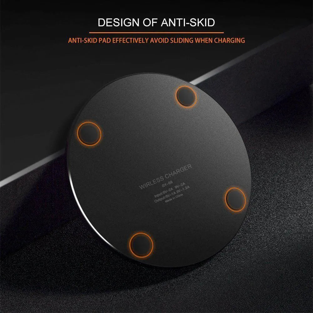 Ultra-thin black aluminium QI wireless charger with USB cable on wooden surface