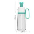 550ml clear glass oil dispenser bottle with stainless steel spray nozzle and a yellow silicone brush head attached.