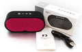Grey portable Bluetooth speaker with TF card slot, USB port, and built-in microphone on a table.