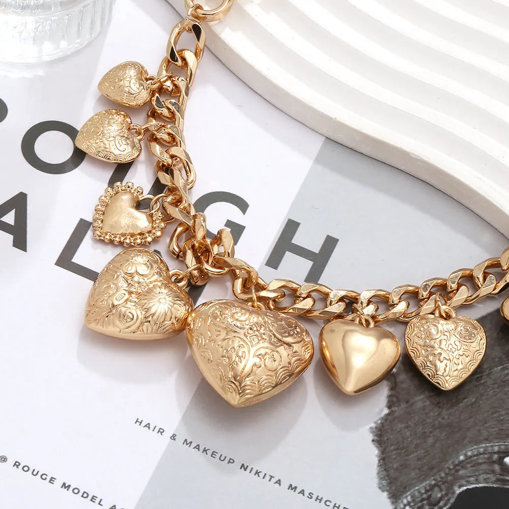 Gold women's necklace with a large, exaggerated heart-shaped pendant on an adjustable chain.