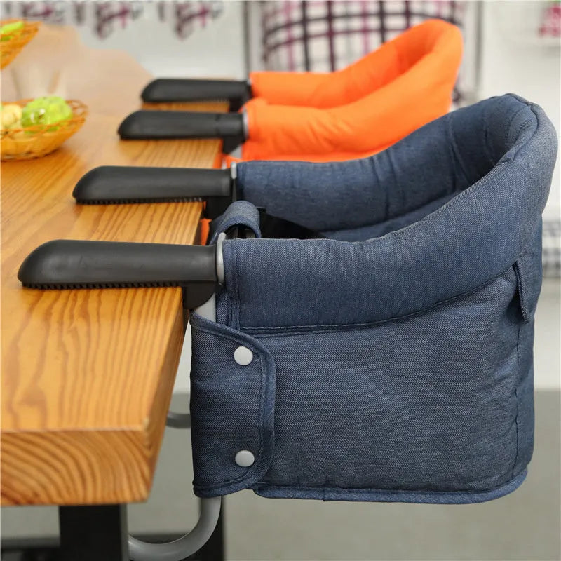 Portable baby high chair seat cover with safety belt in blue colour expanded on dining chair
