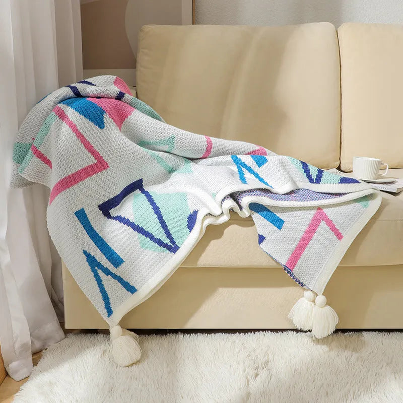 Bohemian-style acrylic knit sofa blanket with tassels in a geometric pattern