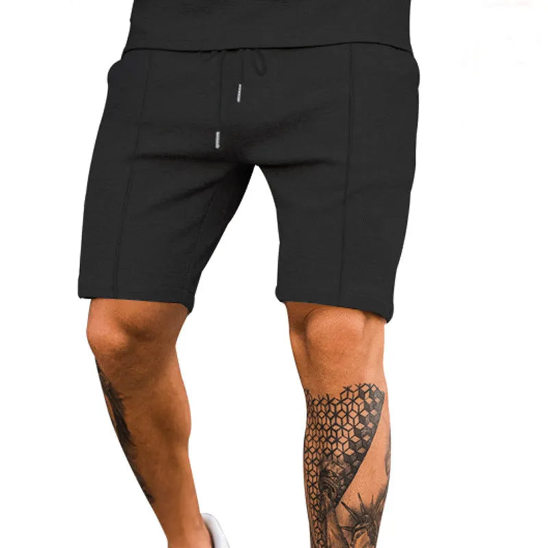 Solid colour five-point polyester sports shorts in khaki with elastic waistband, side view on model