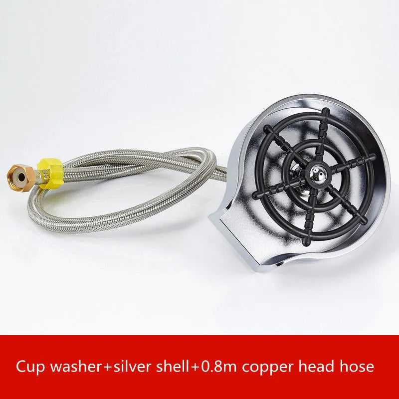 Black automatic cup washer with five-hole nozzle installed on a bar counter sink with a glass being rinsed