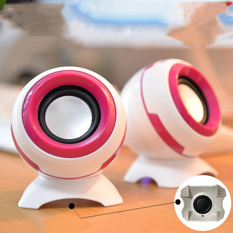 USB-powered computer stereo speakers in black gold and white gold metallic finishes beside laptop