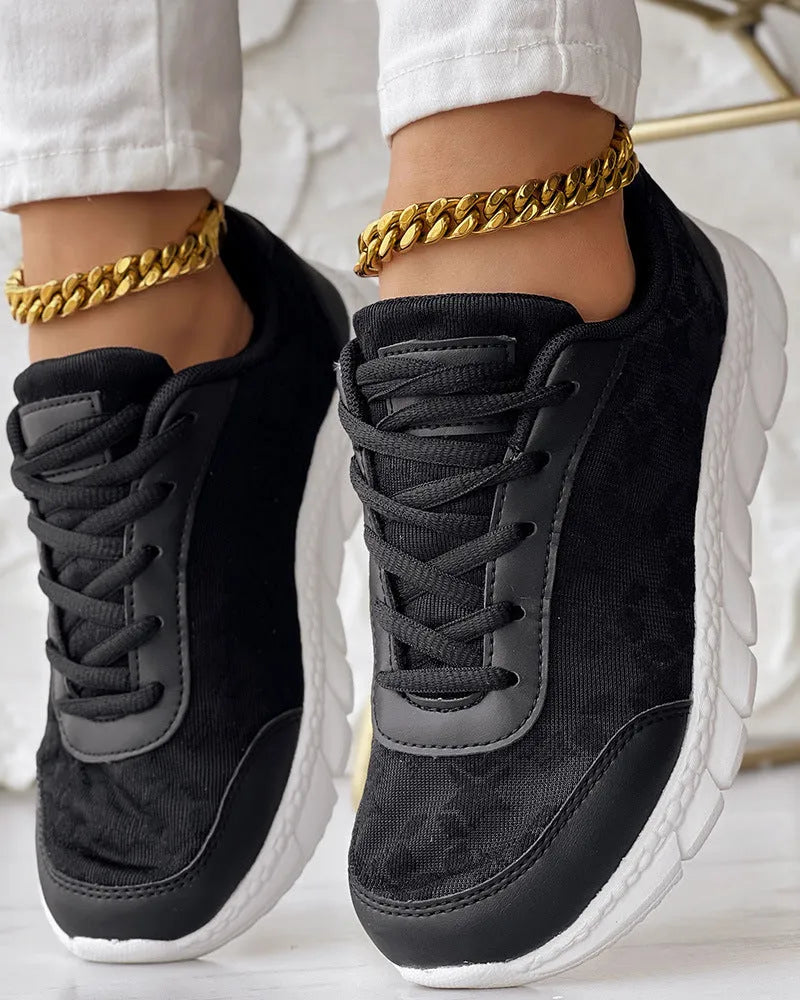 Women's white canvas casual running shoes with flat sole on a light background.