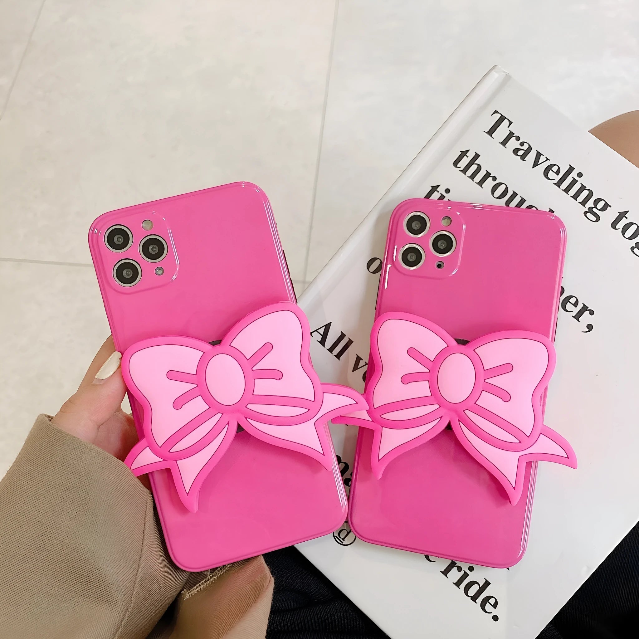 Rose red iPhone case with a pink bow design and a fold-out kickstand on the back.