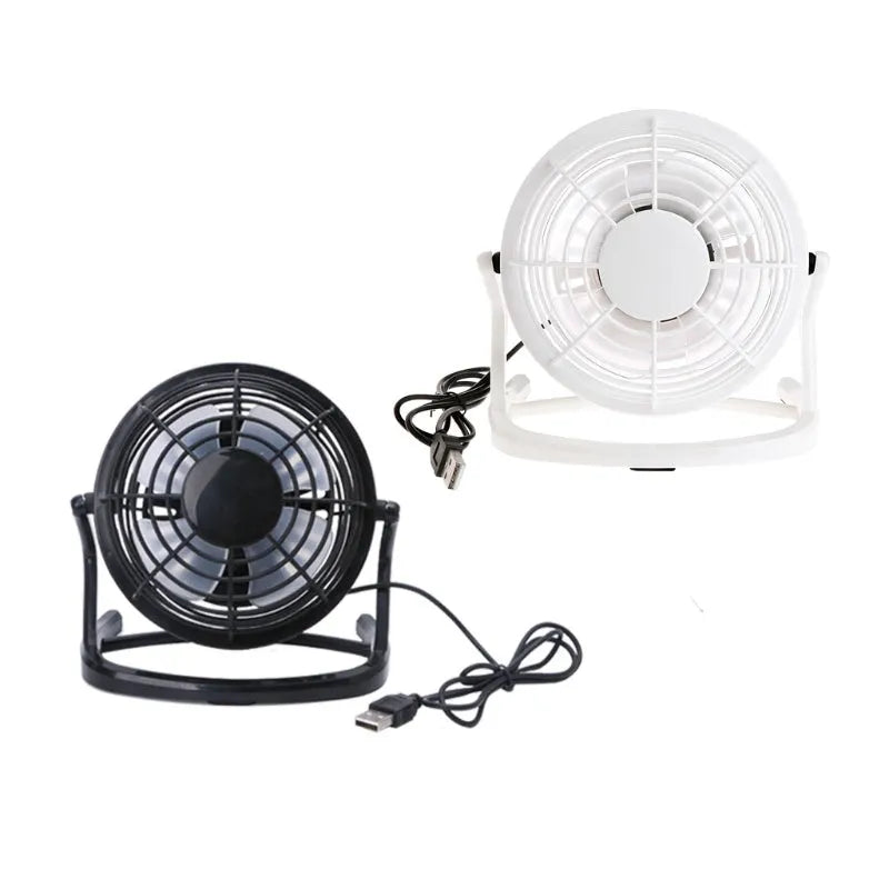 Compact black mini USB desk fan with adjustable tilt on a desk next to a laptop.