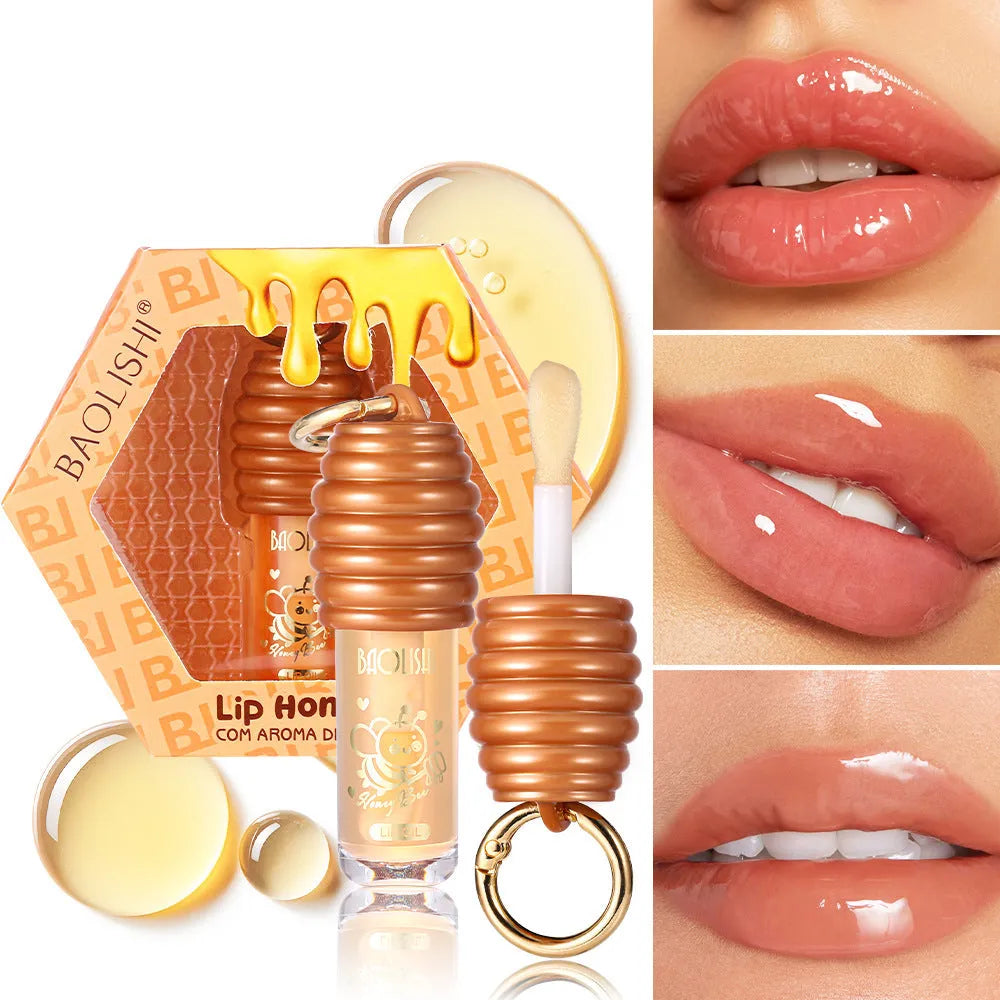 Honey lip gloss attached to a keychain next to a small reusable fabric pannier bag.