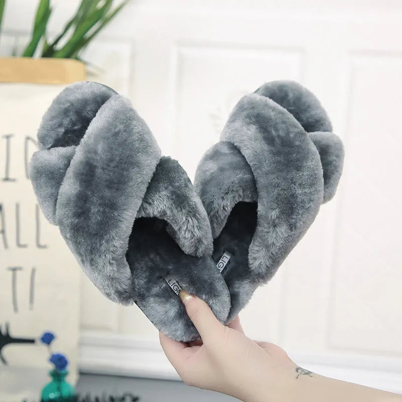 Women's black cross open-toe fur slippers on a white background, showing criss-cross upper and patterned sole.