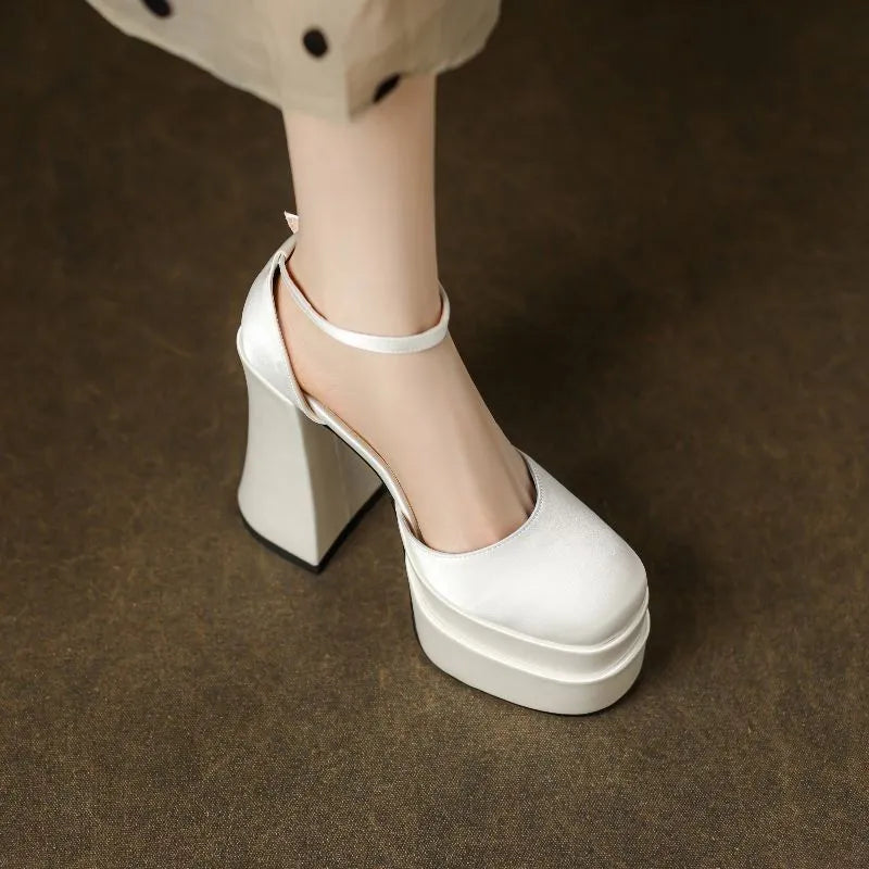 Women's white platform high heels with a chunky heel and round toe on a plain background.