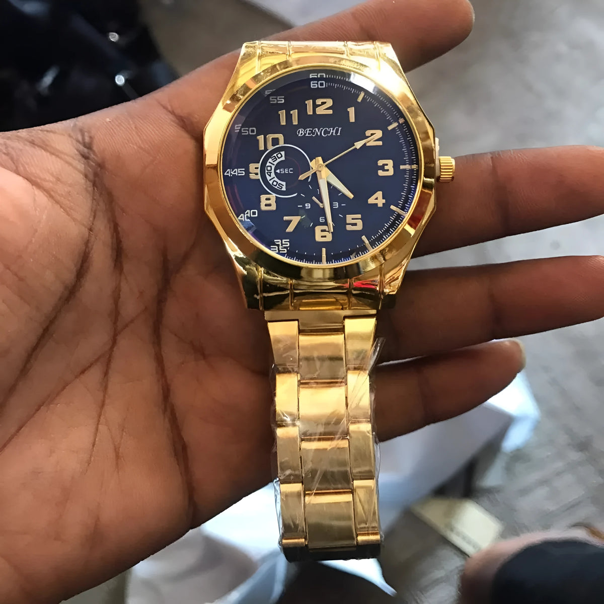 Gold-tone unisex wristwatch with round dial and adjustable metal strap, 40mm case