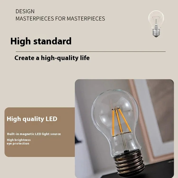 Small black suspension bulb desk lamp with iron art body on a wood grain base.