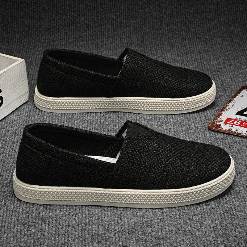 Men's beige canvas slip-on shoes with round toe and PVC sole on neutral background