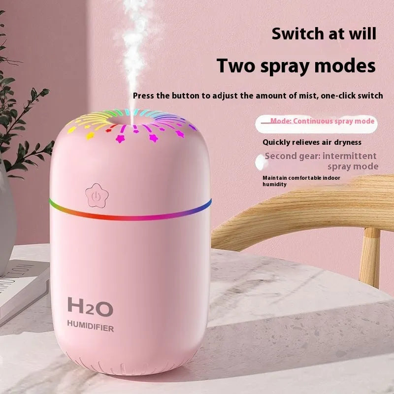White USB portable mini humidifier with water tank on desk beside laptop
