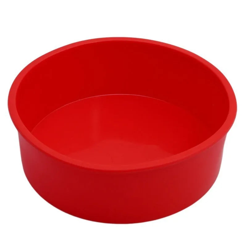 Set of three bright red round silicone cake moulds in 4-inch, 6-inch, and 8-inch sizes on a kitchen counter.