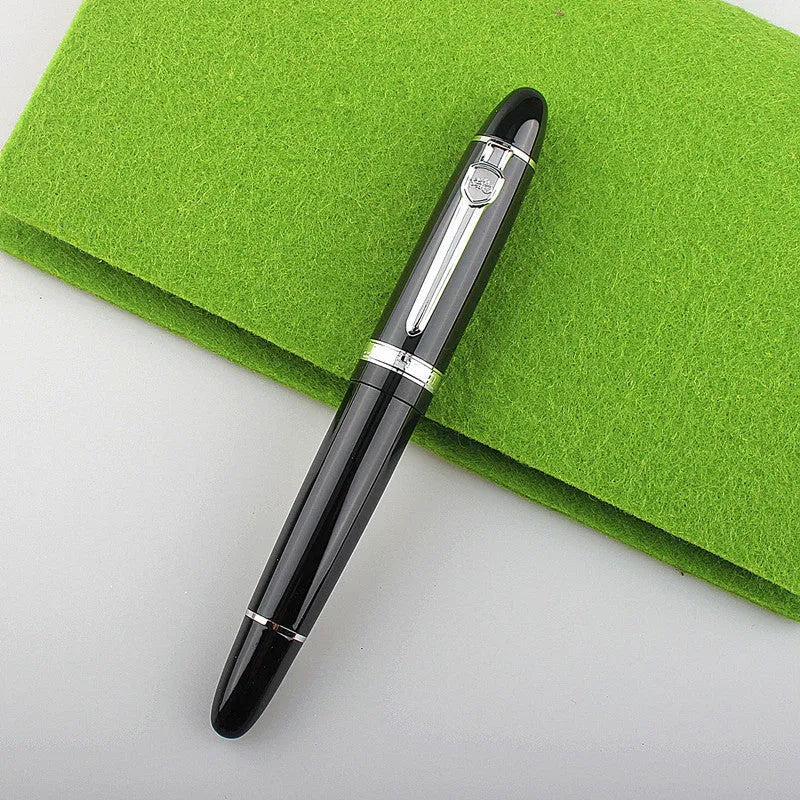 Metal ball pen with pearl beads, black body and silver clip, lying on a desk