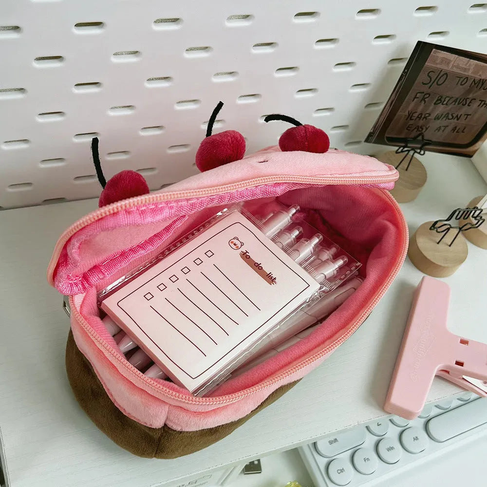 Soft red velvet pencil bag with a cherry cake print and a white zip.