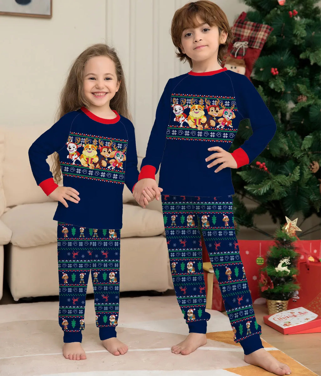 Family wearing matching red plaid Christmas pajamas with deer motif, including parents, children, and a dog.