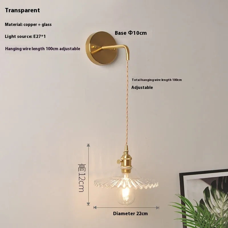 Retro brass wall lamp with a white glass lotus flower shade mounted on a beige wall.