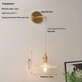 Retro brass wall lamp with a white glass lotus flower shade mounted on a beige wall.