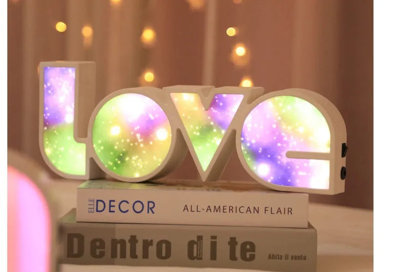 Rainbow coloured LED LOVE word light for Valentine's Day and wedding decoration on a table.