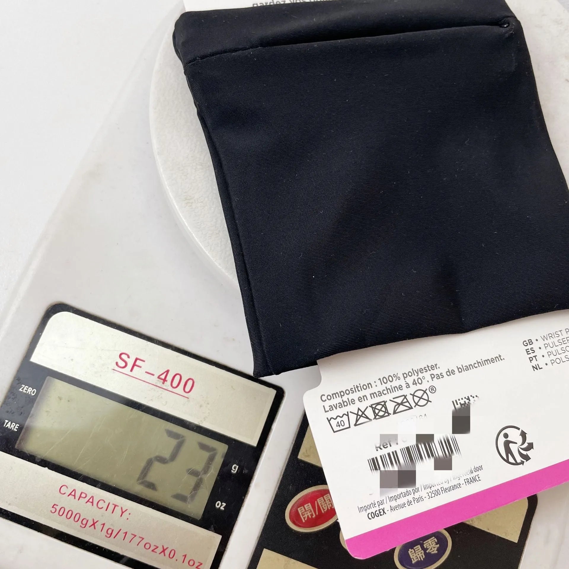 Black wrist sleeve bag with a mobile phone inserted, showing hands-free design on a person's wrist.