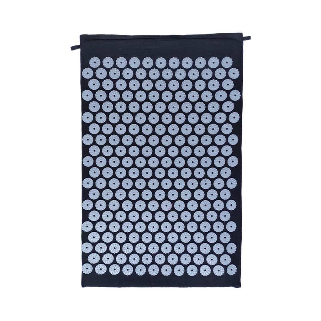Black and blue acupuncture massage mat with cushion and headrest on floor
