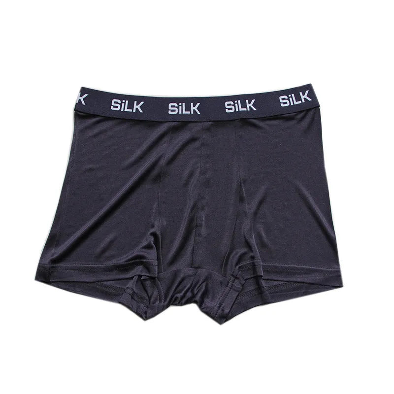 Men's loose fit silk shorts in navy blue on a mannequin, showing mid-waist design.