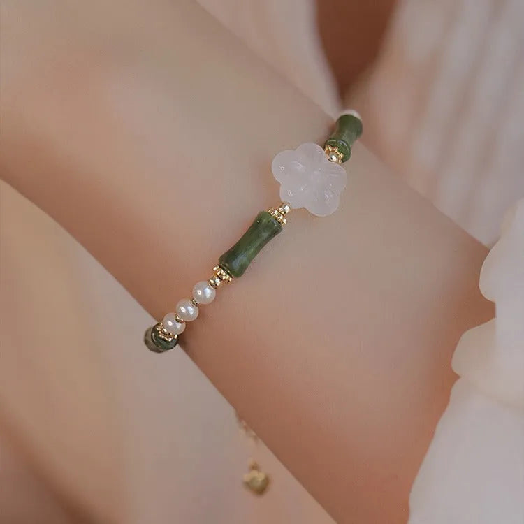 Close-up of a handcrafted Chinese antique style bracelet with bamboo joint design, featuring Hetian jade and 4mm shell pearls with copper details.