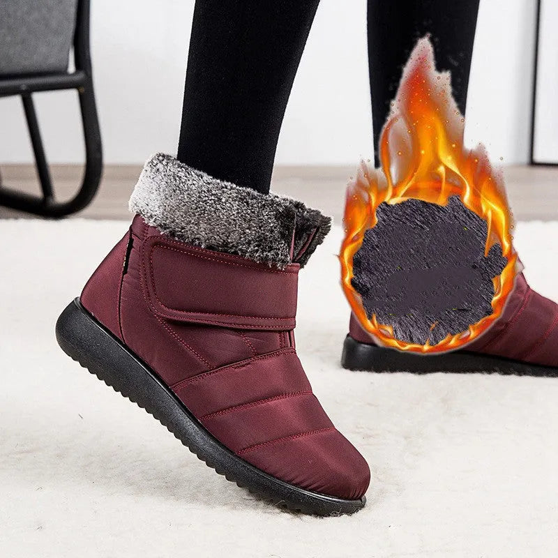 Women's winter snow boots with plush lining, suede upper, velcro strap, flat heel, and anti-skid rubber sole in black.