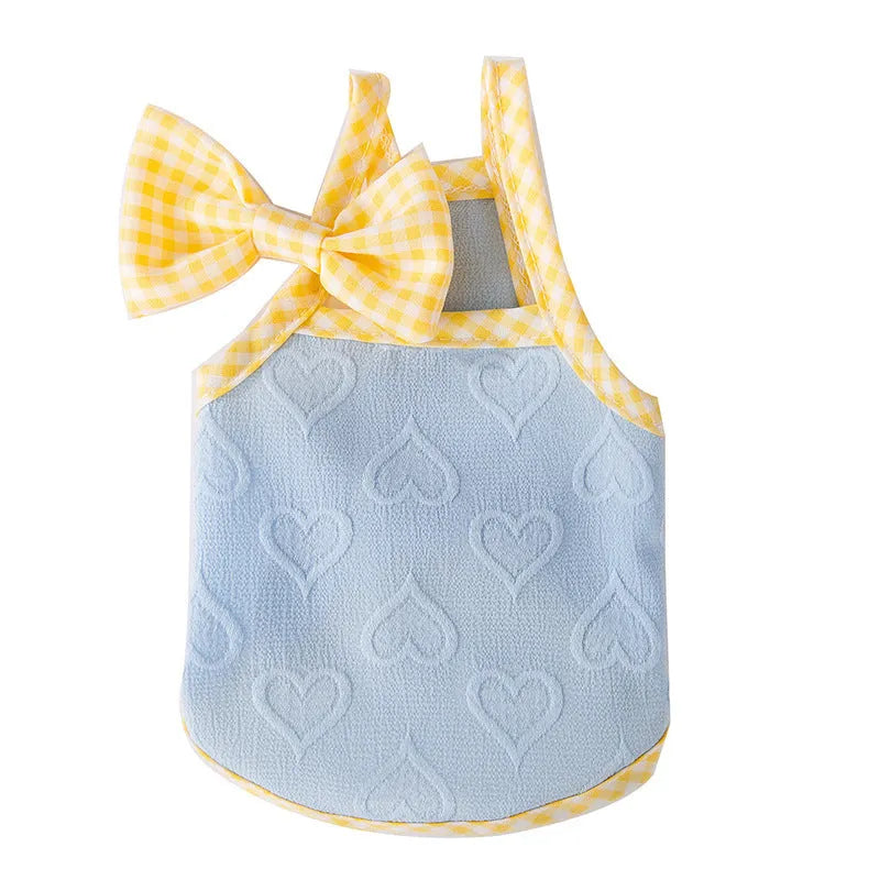 Small dog wearing a blue elastic vest with a bow and heart texture on the suspenders.