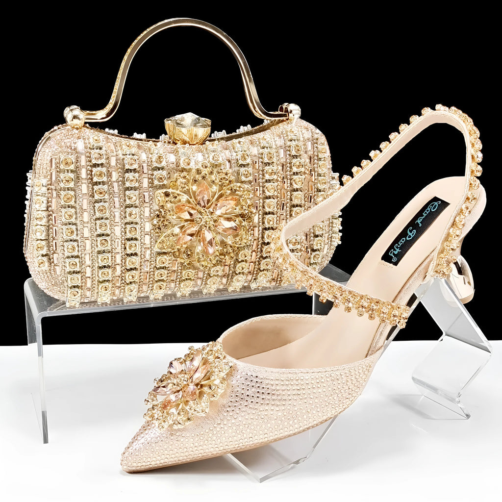 Women's black high-heel ankle boots with chain buckle flower decoration and a matching hard clutch bag.