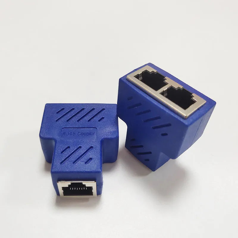 Two white RJ45 three-way tee network cable splitters on a dark surface.