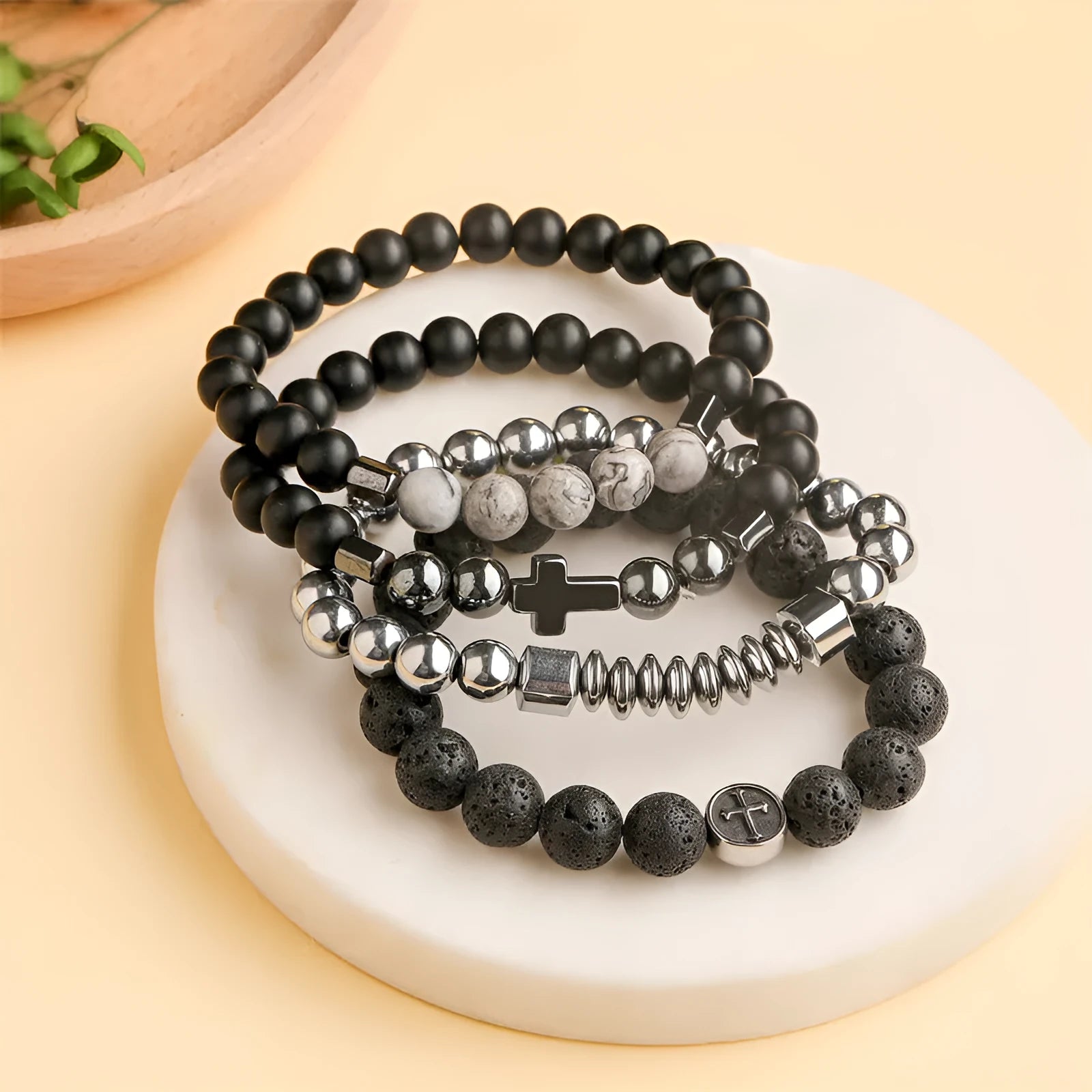Close-up of a men's bracelet with black volcanic agate beads in a geometric shape on a stainless steel chain.