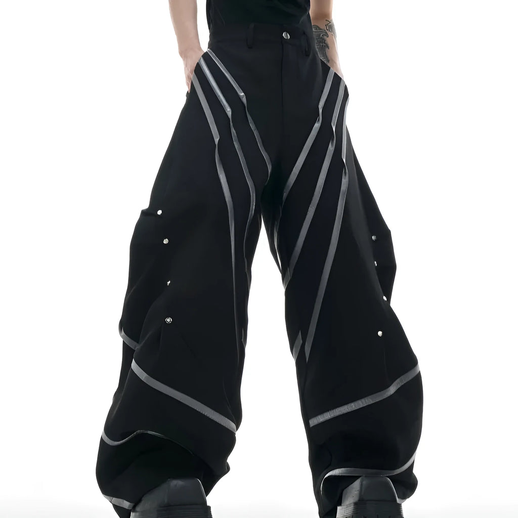 Men's black polyester trousers with three-dimensional cut and metal striped rivets on the pleats.