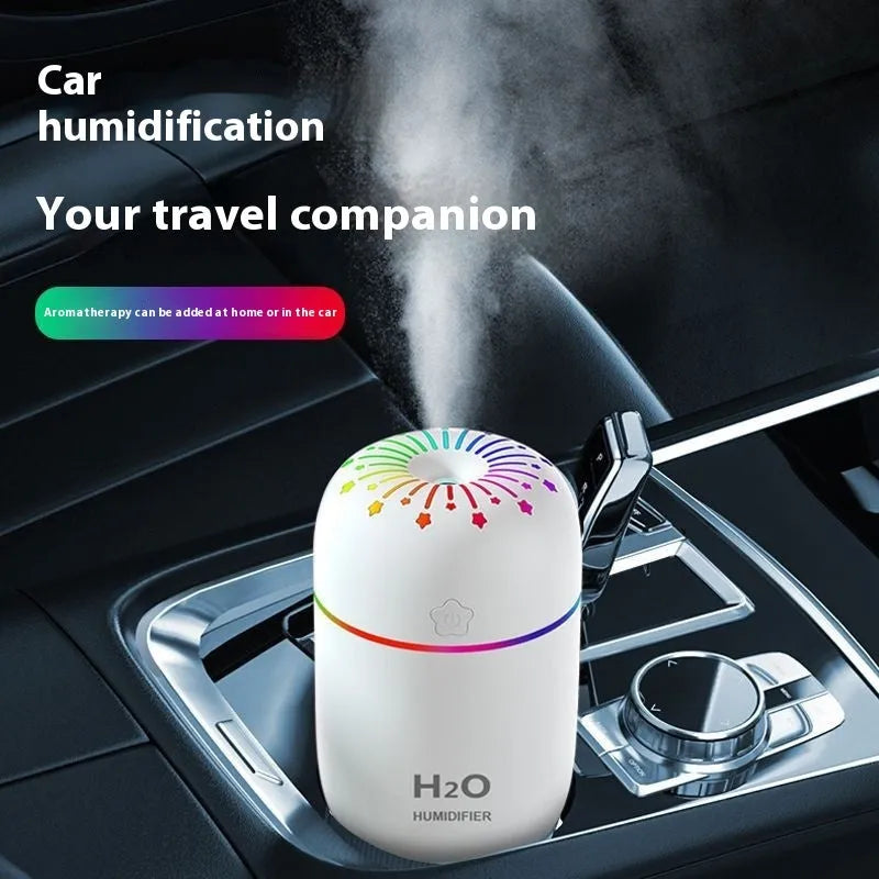White USB portable mini humidifier with water tank on desk beside laptop