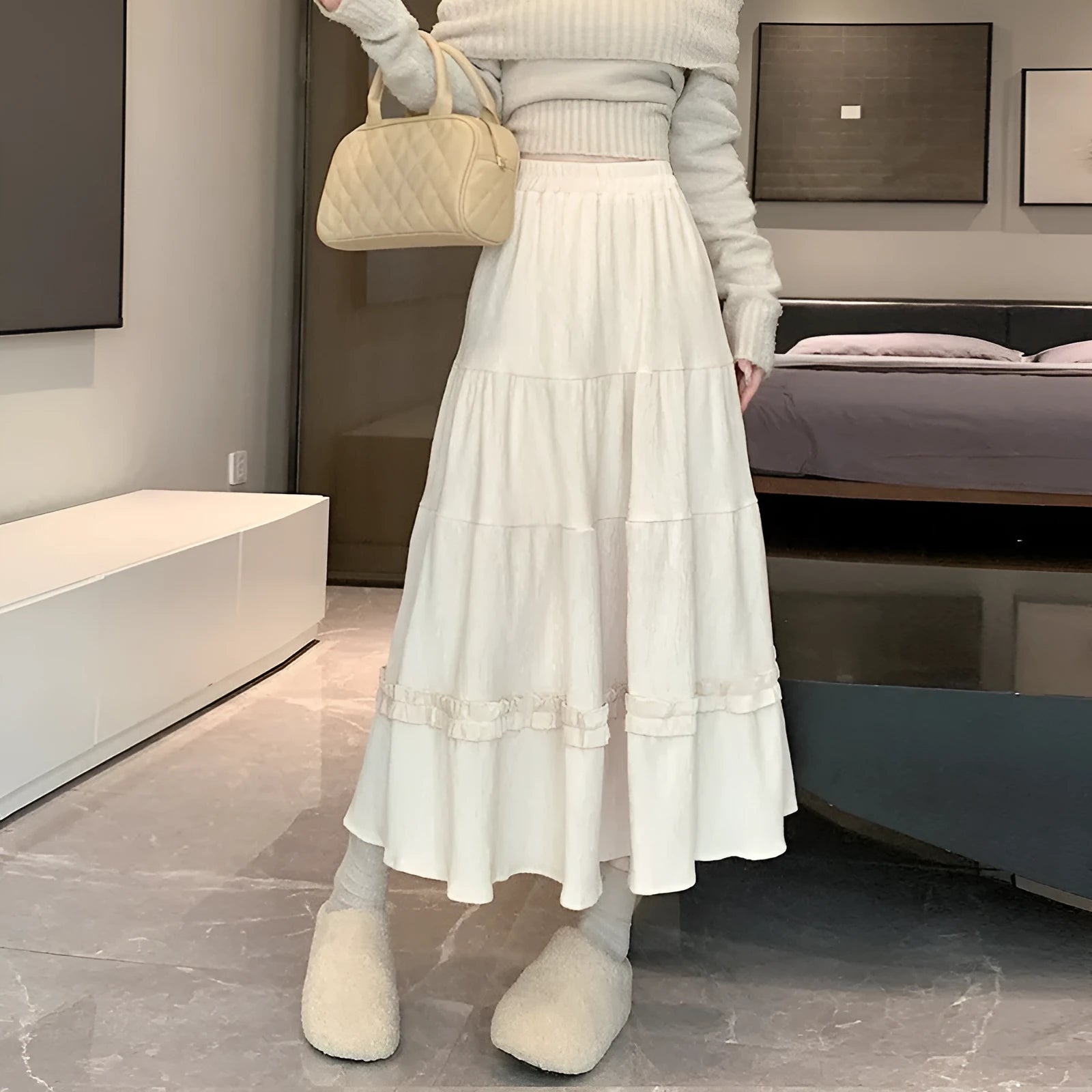 Beige corduroy A-line midi skirt with an elastic waistband laid flat.