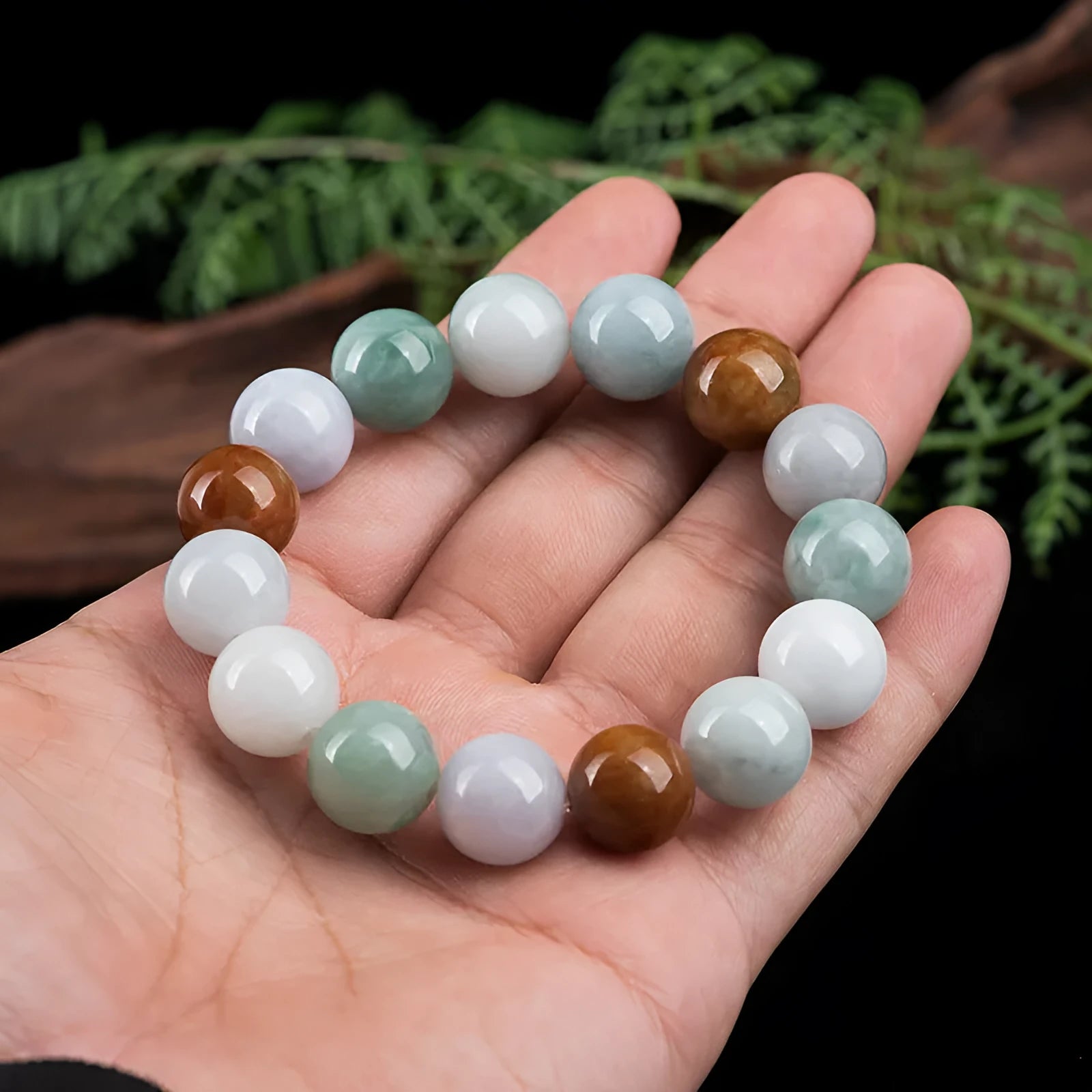 Close-up of a women's bracelet with round 13mm Myanmar jade beads in three colours.
