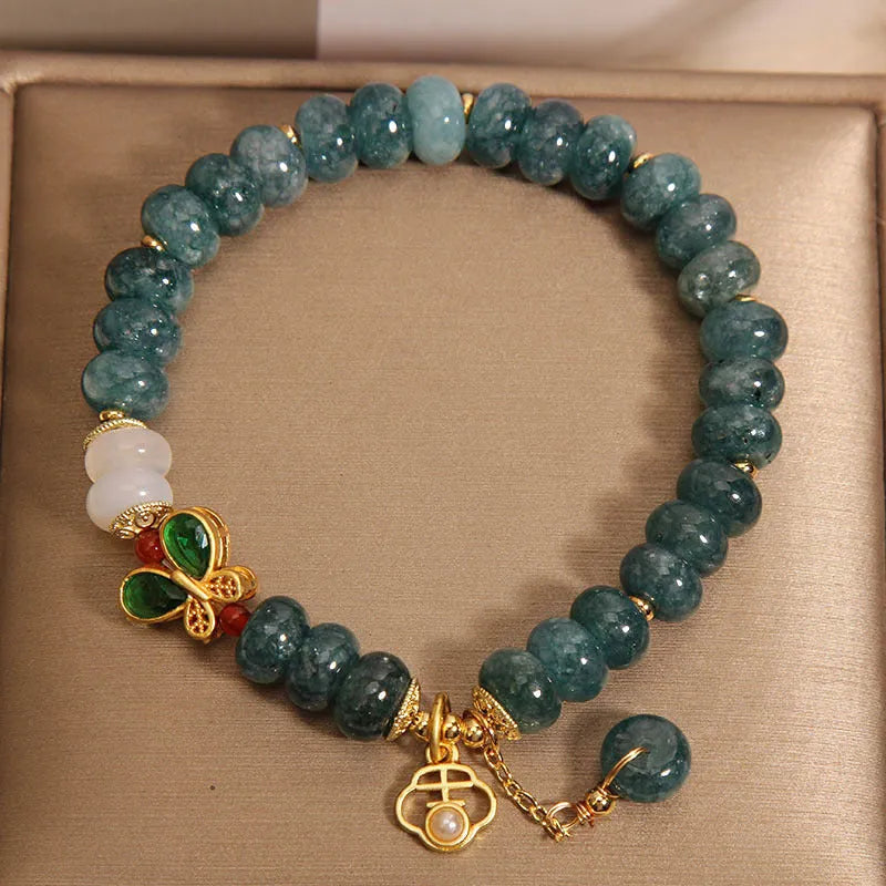 Blue water jade and white agate abacus bead bracelet with alloy inlay, rhinestones, and butterfly charm.