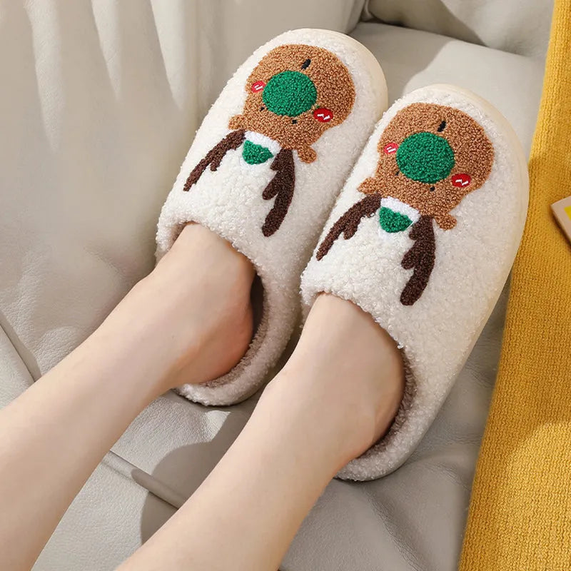Christmas winter home slippers in red with plush upper and anti-slip sole on a wooden floor