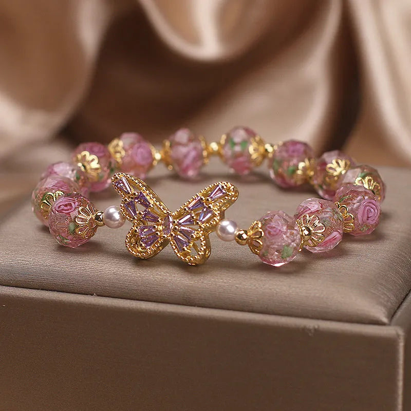 Pink crystal cherry blossom butterfly bracelet with hollow zircon accents on white background