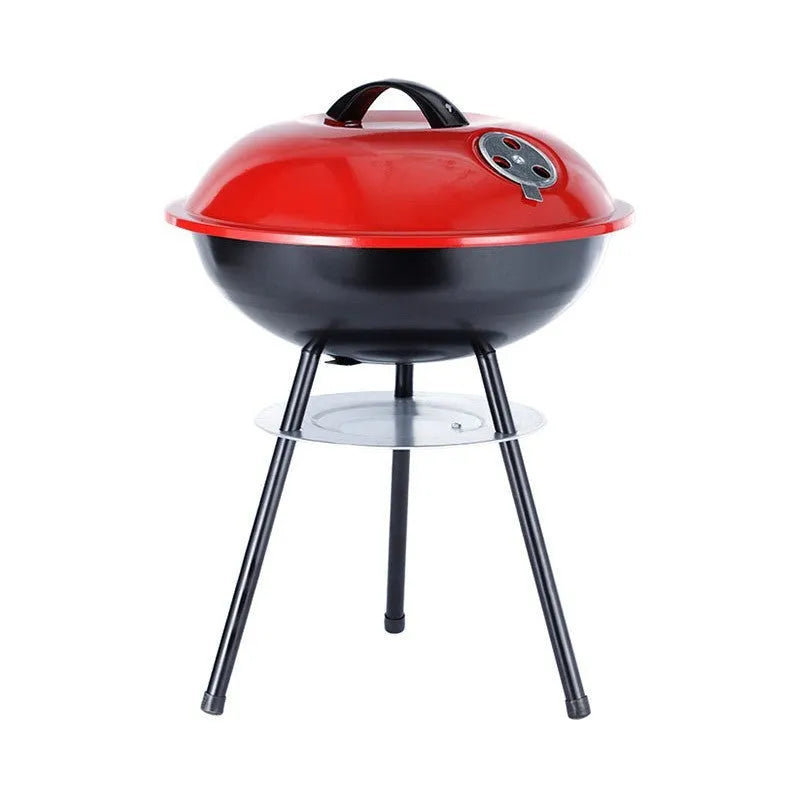 A compact, circular portable barbecue oven with a 14-inch cast iron grill grate, shown on a patio.